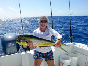 Woman holding her mahi-mahi catch.