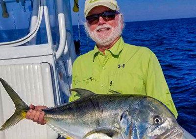 Man in green shirt holding a Jack Crevalle